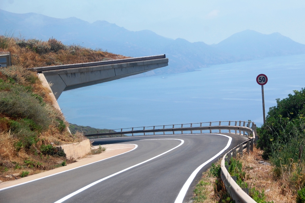 Slingrande vägar på Sardiniens västkust med överhäng som hindrar jord och sten att rasa över bilarna