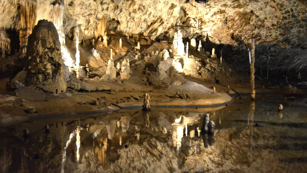 Stalagmiter och stalagtiter som speglar sig i en underjordisk sjö